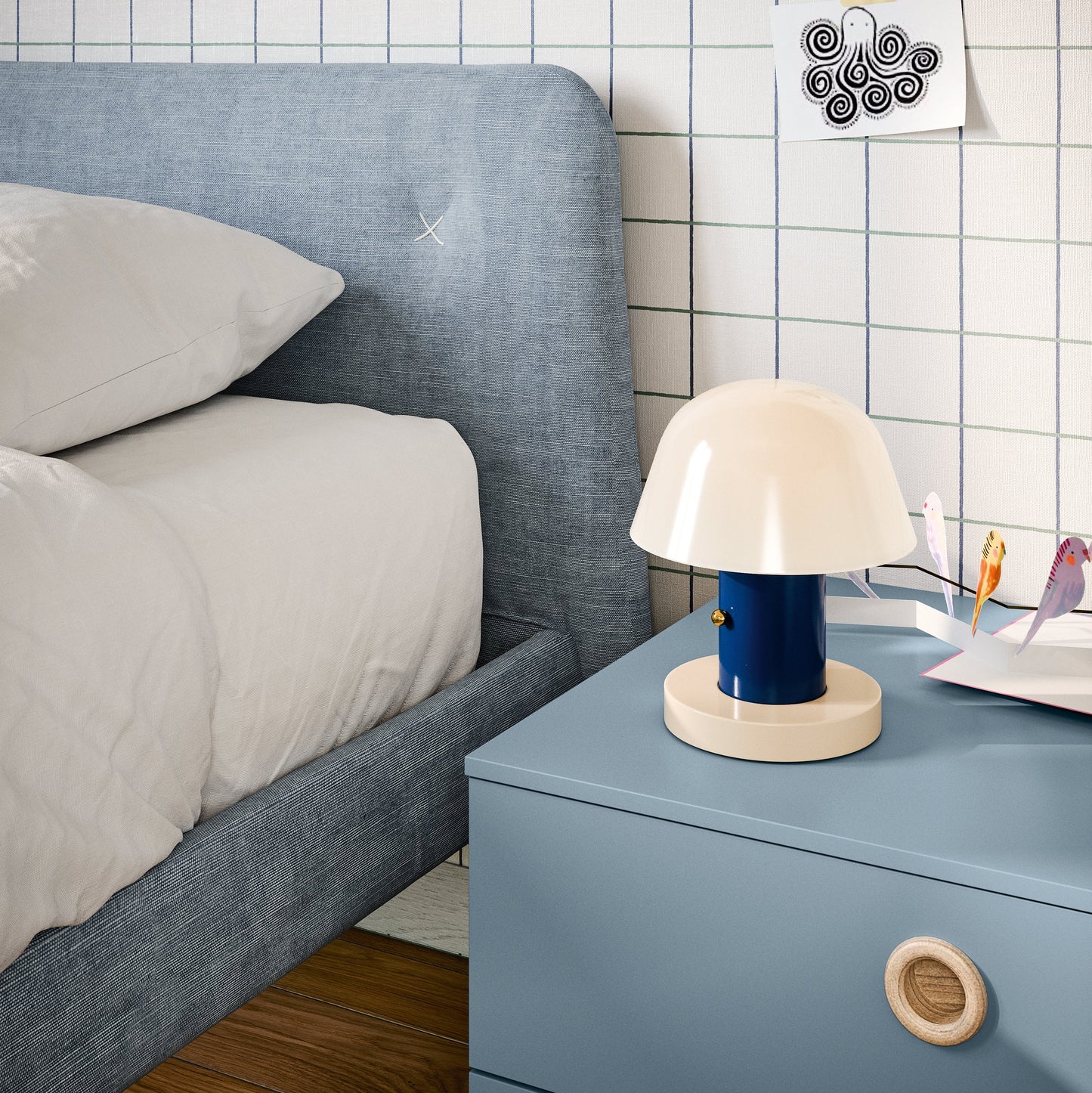 Close-up of upholstered Nidi kids bed with blue nightstand and soft modern bedroom details.