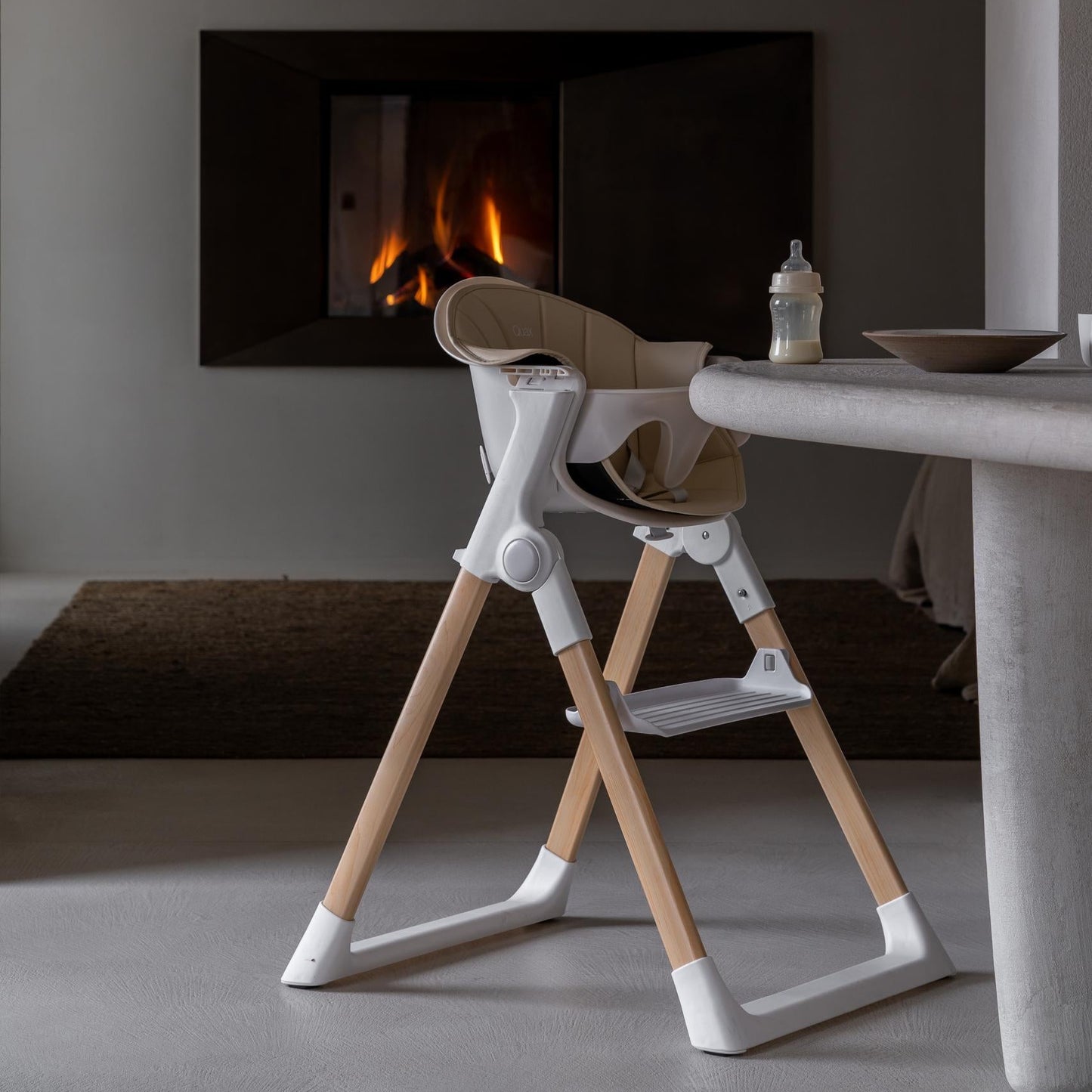 Wooden high chair in a modern room with a fireplace.
