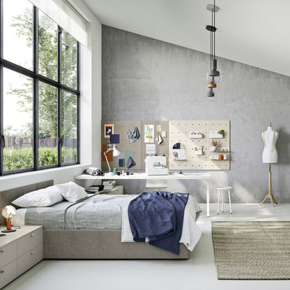 A modern, bright bedroom interior with a bed, desk, shelving, mannequin, and large window, shown as a styled room scene rather than a single isolated product.