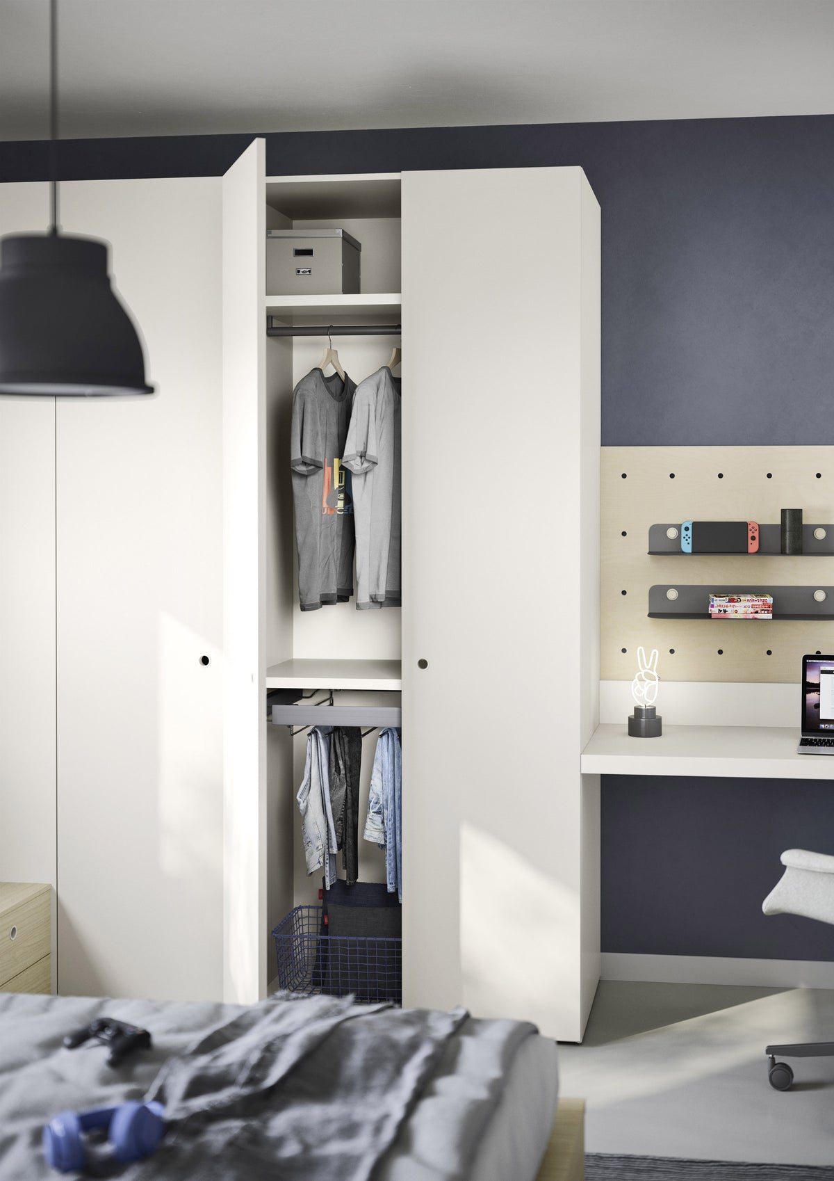 A Teen modern white wardrobe with one door open, showing hanging gray shirts and a storage box inside, set in a bedroom with a dark navy wall, desk, and pegboard.