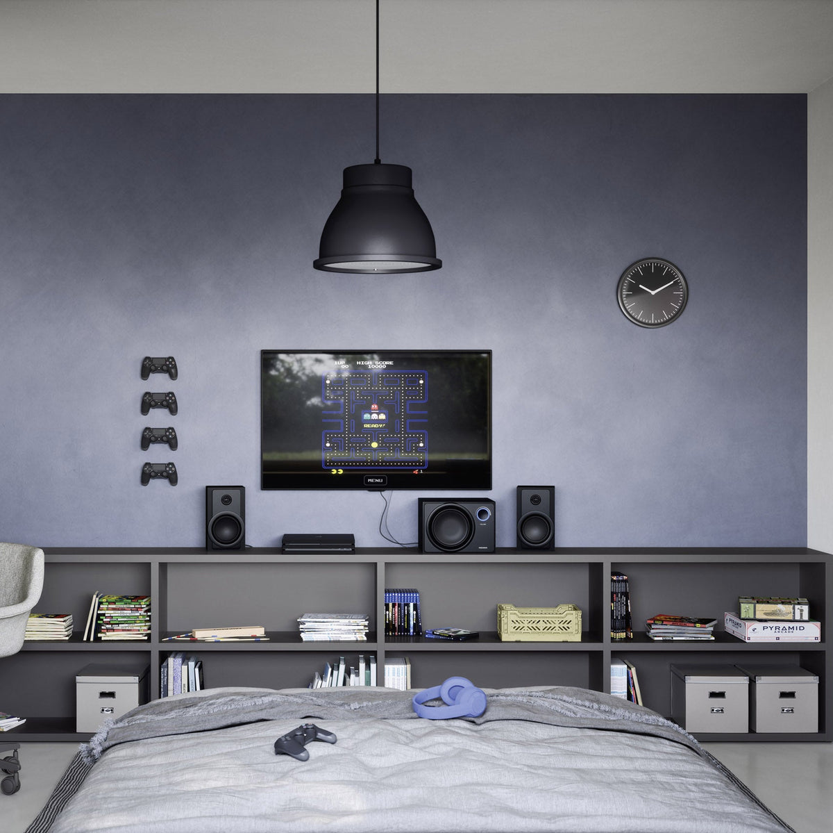 A modern bedroom or gaming room setup with a dark gray wall, a black pendant light, a built-in media console with speakers and a TV, a desk with a white chair, and a bed in the foreground.