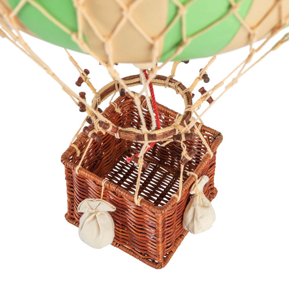 Wicker basket of a hot air balloon with a green balloon on a white background