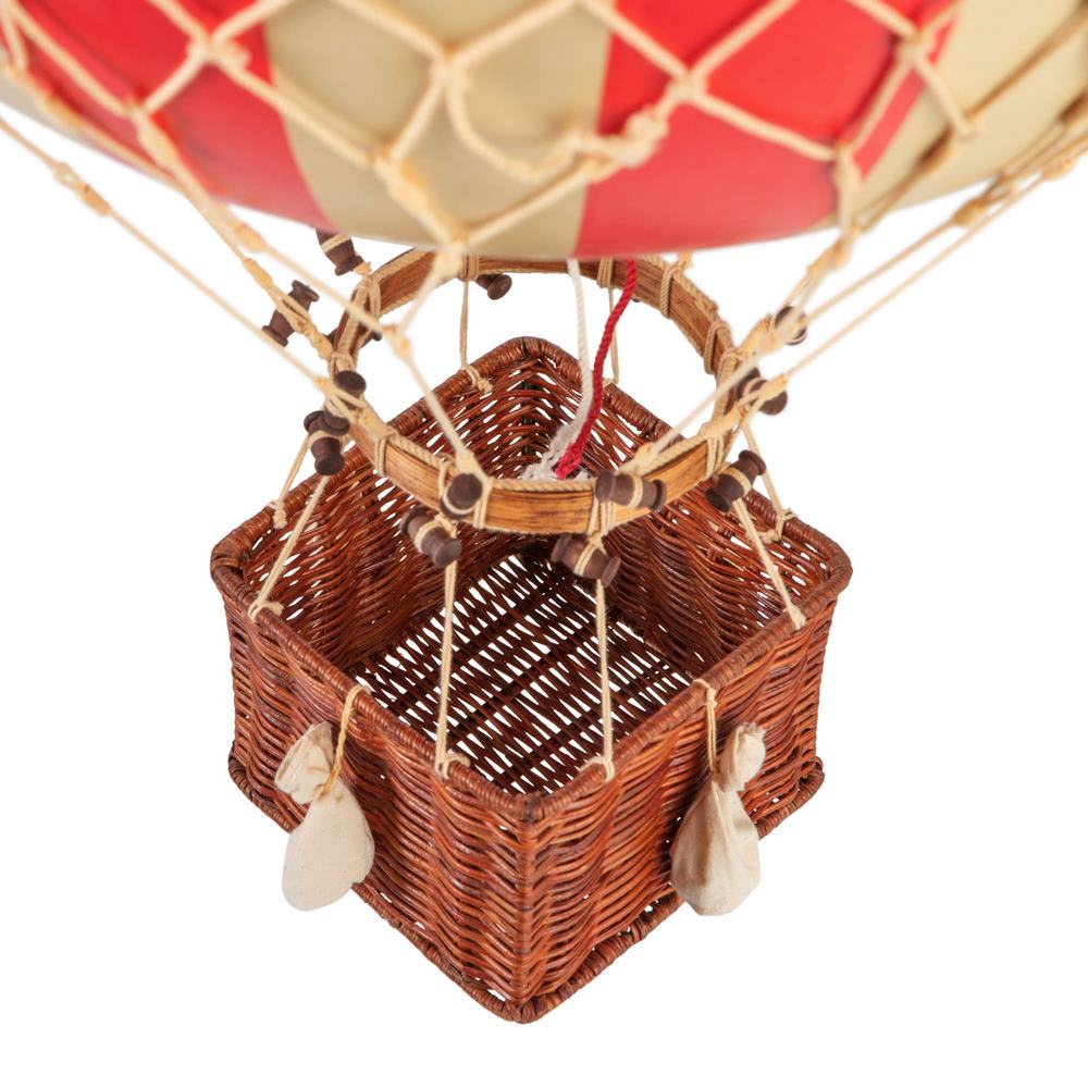 Close-up of a wicker basket attached to a hot air balloon with a red envelope.