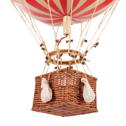 Hot air balloon with red and white striped balloon and wicker basket on a white background