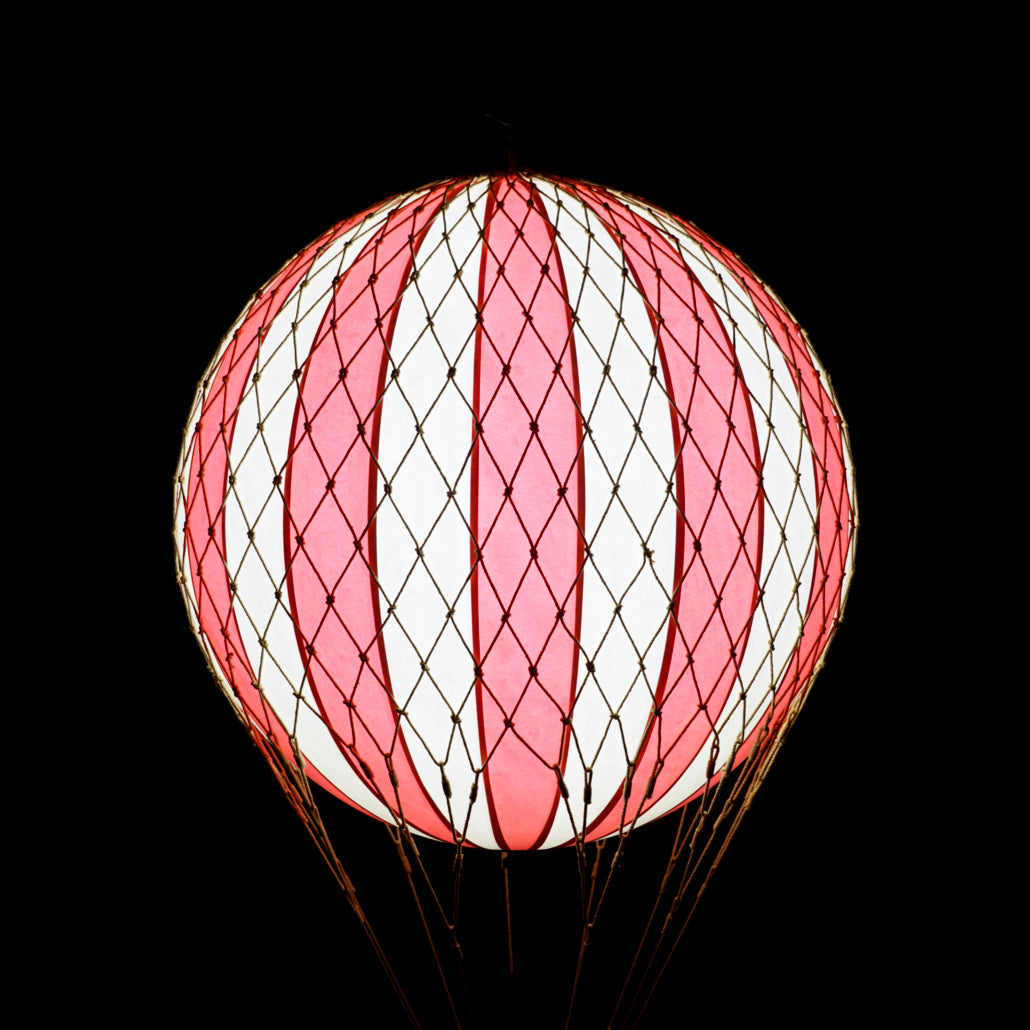 Pink and white striped spherical lantern on a black background