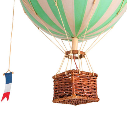 Hot air balloon with green and beige striped balloon and wicker basket on a white background