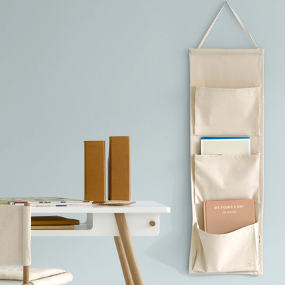 Beige wall-mounted organizer with books on a light blue wall
