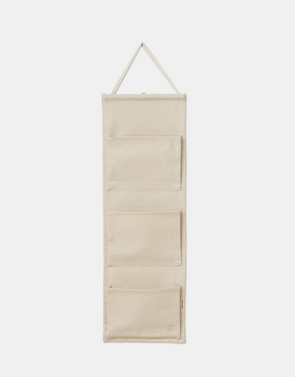 Beige hanging organizer with multiple compartments on a white background