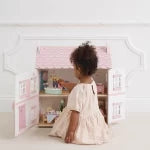 Child playing with a toy kitchen set on a white floor.