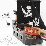 Toy pirate ship with cannon and skull and crossbones flag on a black background