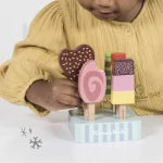 Child playing with a toy kitchen set on a white background