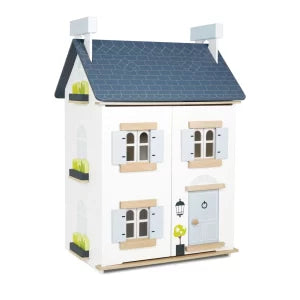 Toy dollhouse with a blue roof on a white background