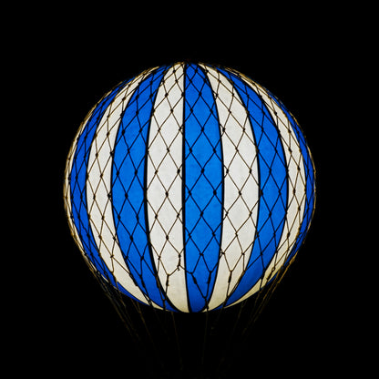 Blue and white striped balloon against a black background