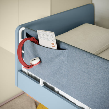 Blue bed with a pocket holding a red lanyard and white card on a beige background