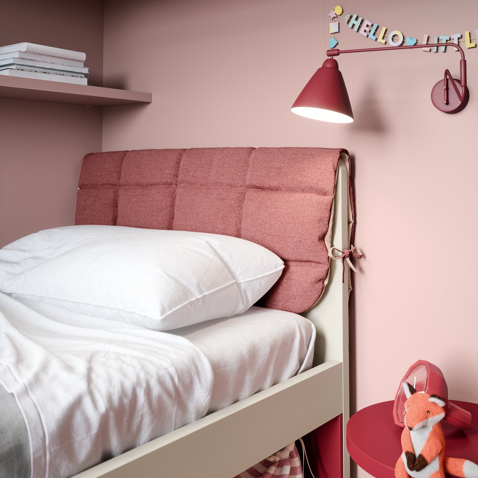 Close-up of Nidi Kids Space 10 bed with pink upholstered headboard, wall shelf, and bedside storage