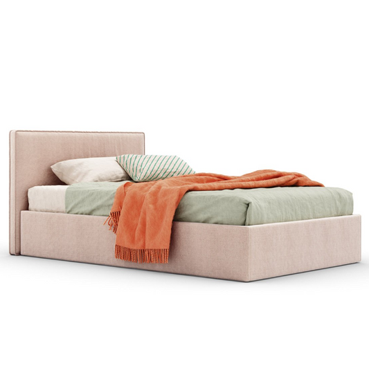 Beige upholstered teen bed with colorful bedding on a white background