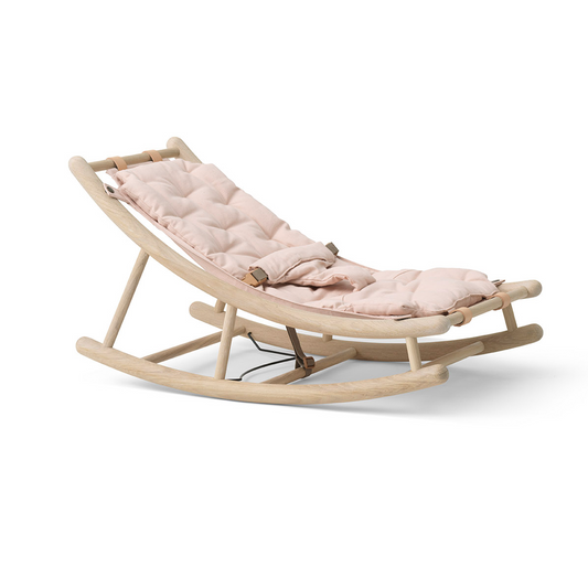 Wooden baby rocker with pink cushion on a white background