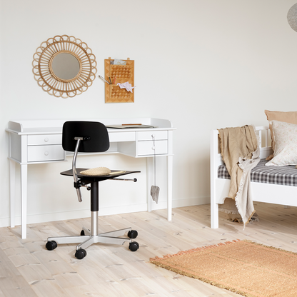Home office with white desk, black chair, and wall decorations.