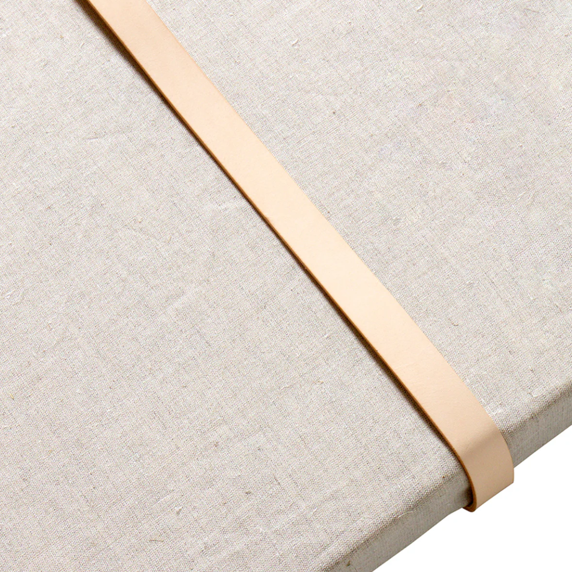 Close-up of a beige fabric surface with a gold ribbon