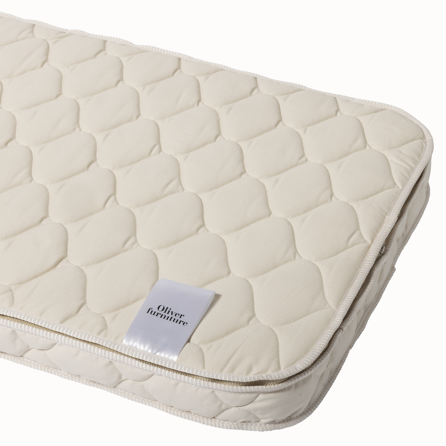 Beige quilted mattress cover with 'Oliver Furniture' label on a white background