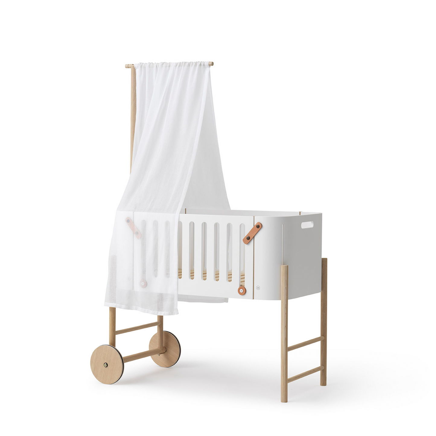 White crib with wooden legs and wheels on a white background