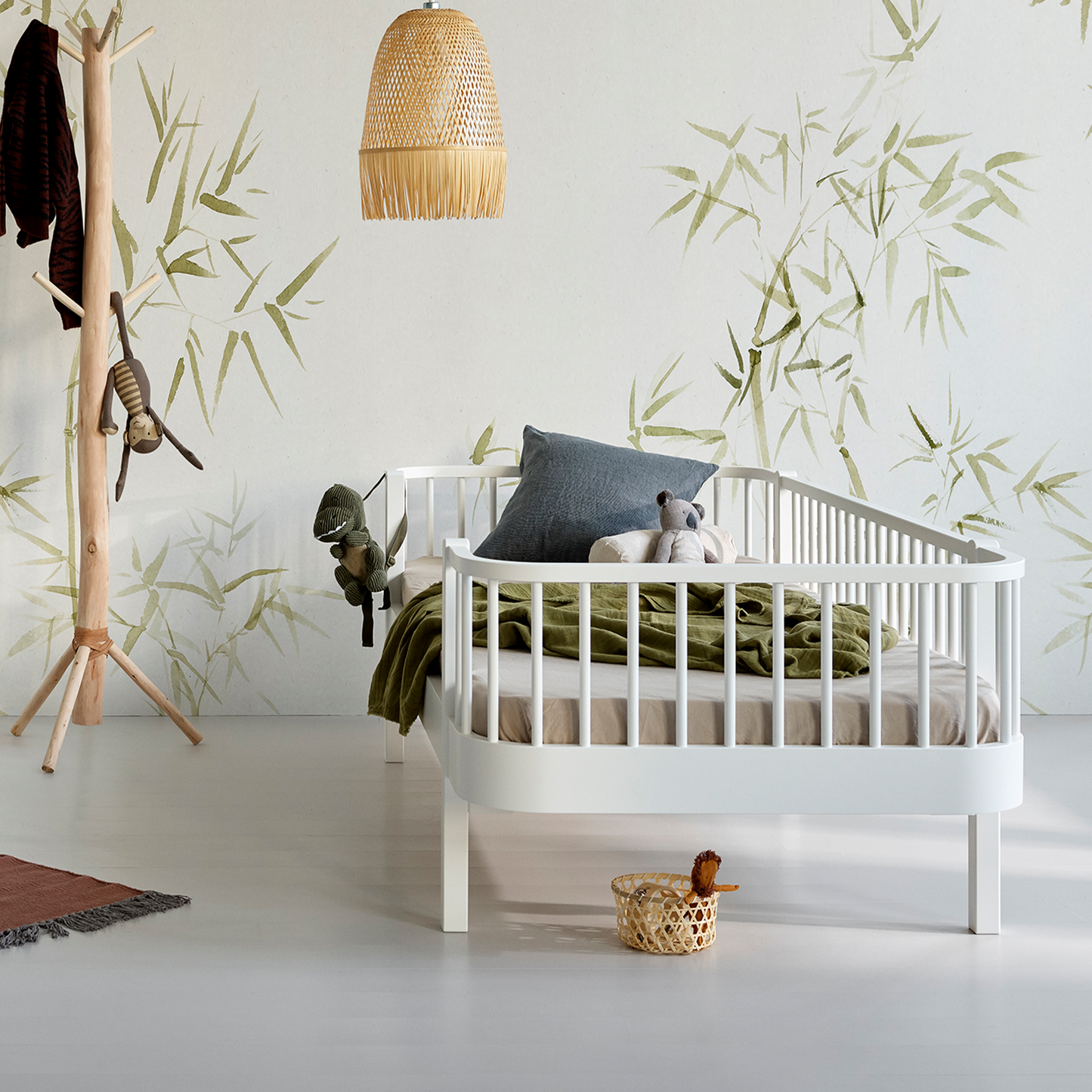 White Kids Day bed, bamboo-themed wallpaper, and wooden coat rack.