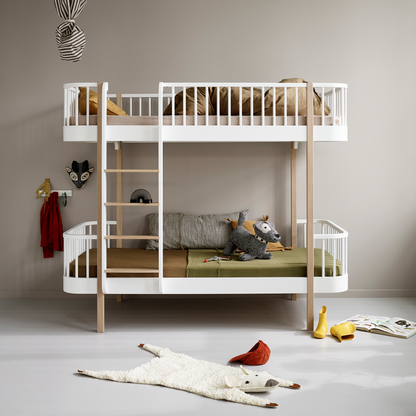 Children's room with a white bunk bed and toys on the floor.