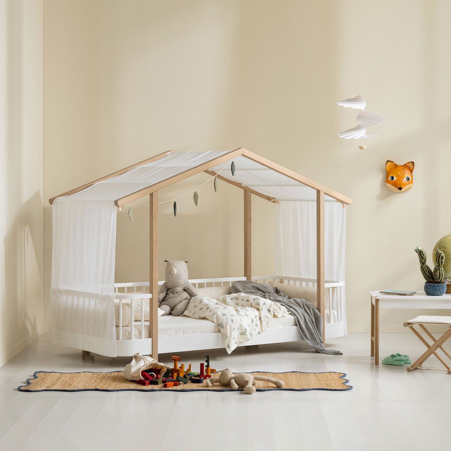 Children's room with a modern crib and toys on a light-colored floor.