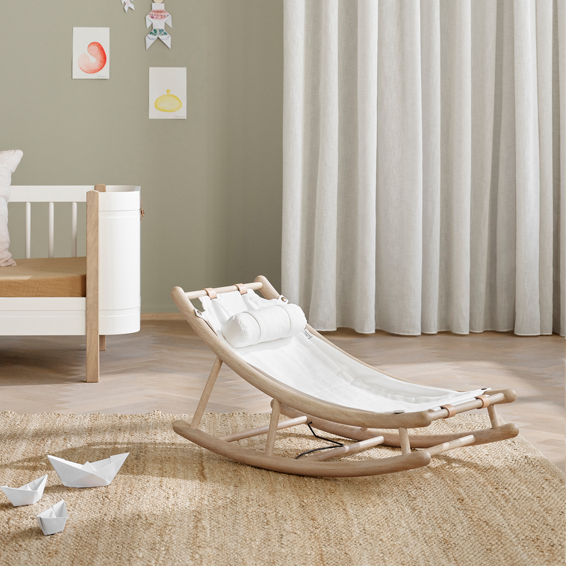 Nursery room with a rocking chair, crib, and decorative elements.