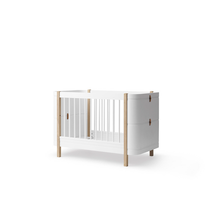 White crib with wooden frame on a white background
