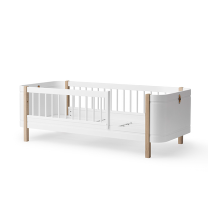 White crib with wooden accents on a white background