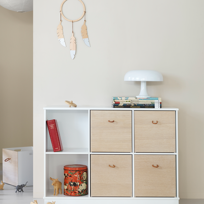 White shelf with wooden drawers and decorative items against a plain wall.
