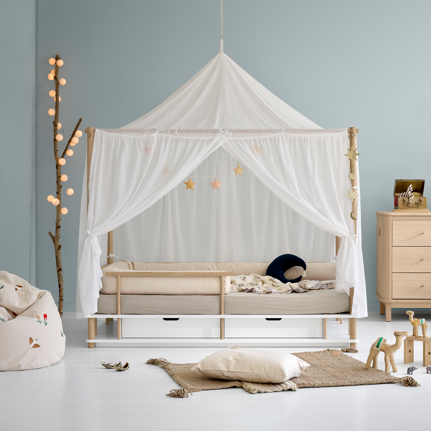 Children's room with a canopy bed, toys, and a dresser.