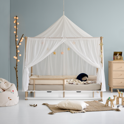 Children's room with a canopy bed, toys, and a dresser.