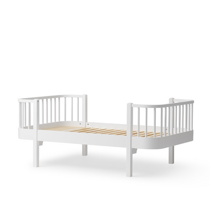 White crib with wooden slats on a white background