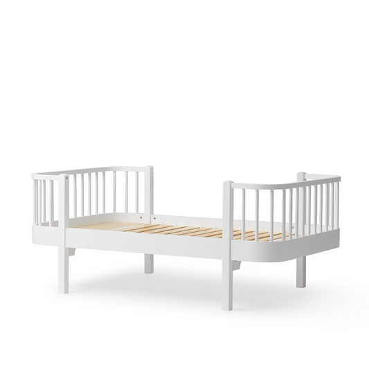 White crib with wooden slats on a white background