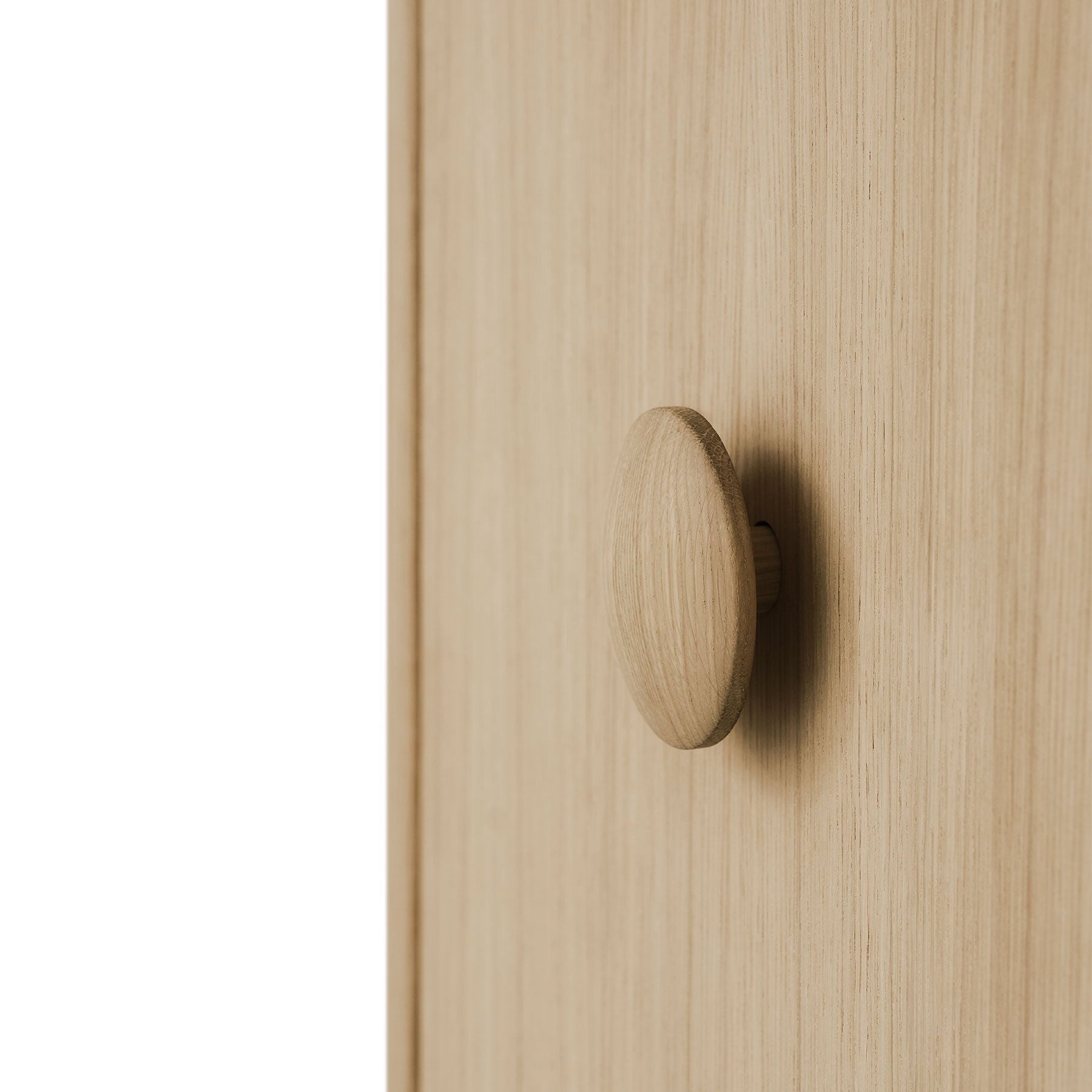 Wooden cabinet door with a round knob on a light wood background
