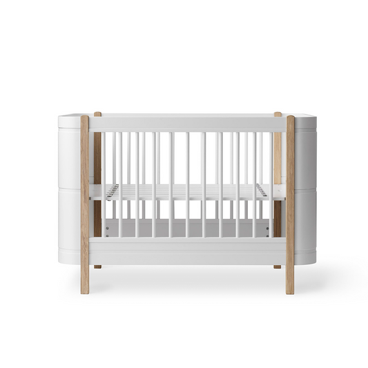 White crib with wooden sides on a white background
