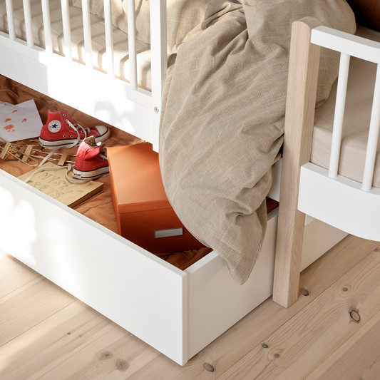 Children's bed with storage compartment and toys underneath