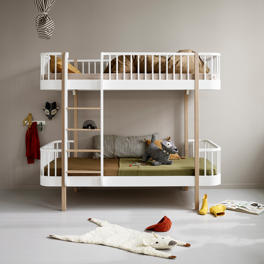 Children's room with a white bunk bed and toys on the floor.
