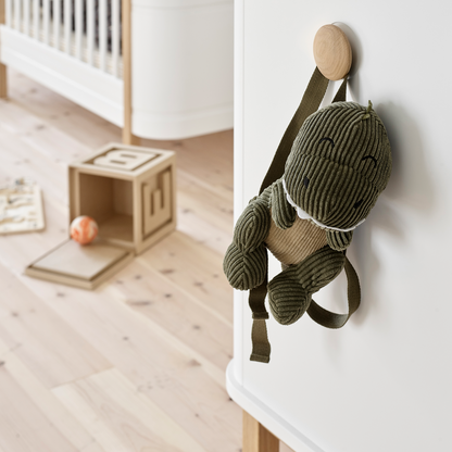toy dinosaur hanging on white and Oak cupboard