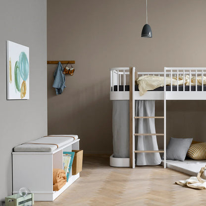 Children's room with a white bunk bed, storage bench, and wall art.