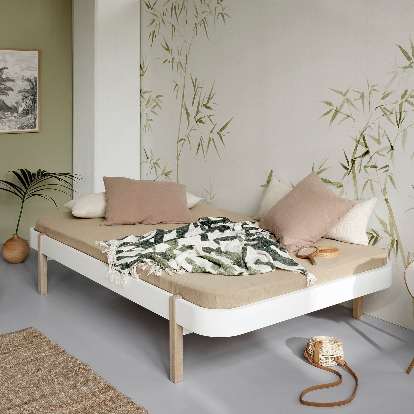 Minimalist bedroom with a bed, pillows, and decorative elements.