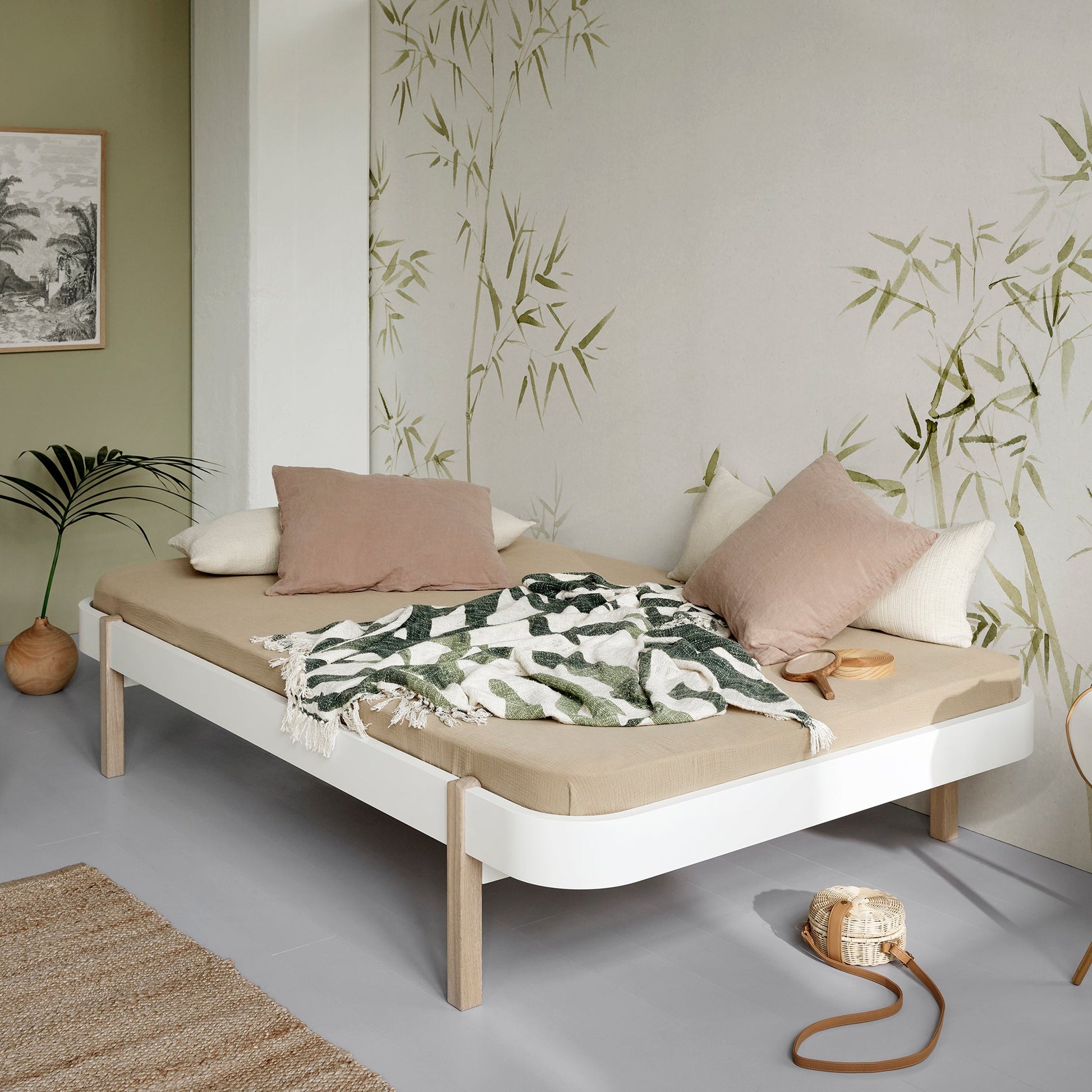 Minimalist bedroom with a bed, pillows, and decorative elements.