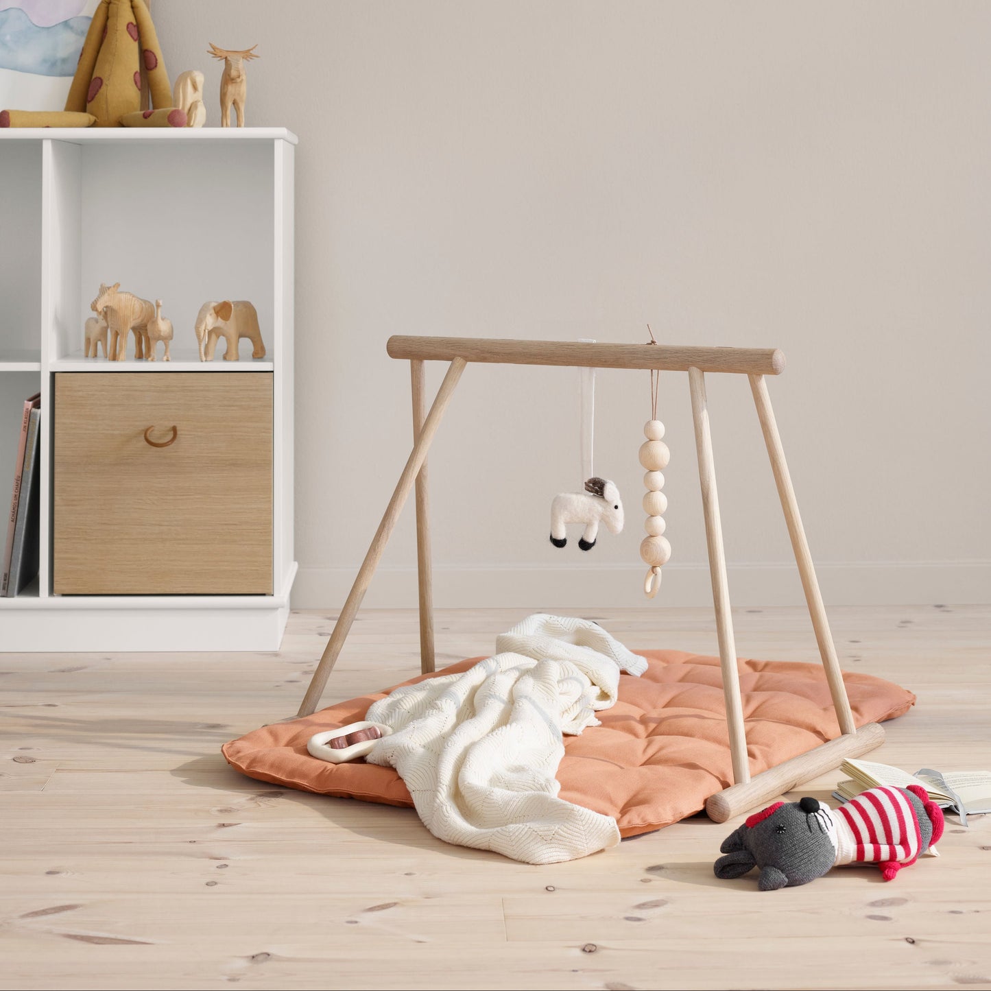 Children's play area with a wooden swing and toys on a wooden floor.