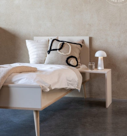 Quax Flow Junior Bed in Clay styled in a neutral children's bedroom with linen bedding and wall art