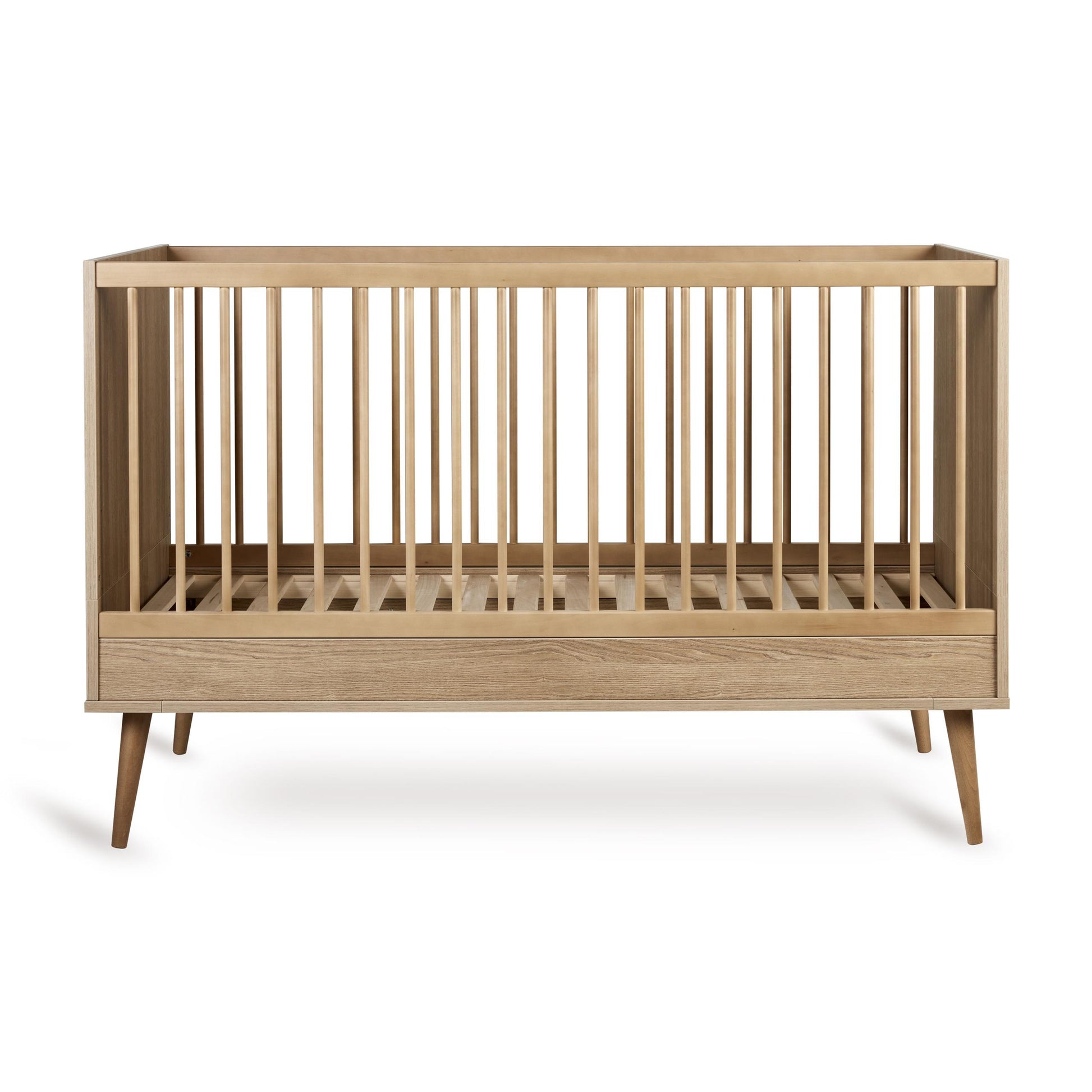 Close-up of the honey ash wood finish and spindle detail on the Quax Flow cot bed