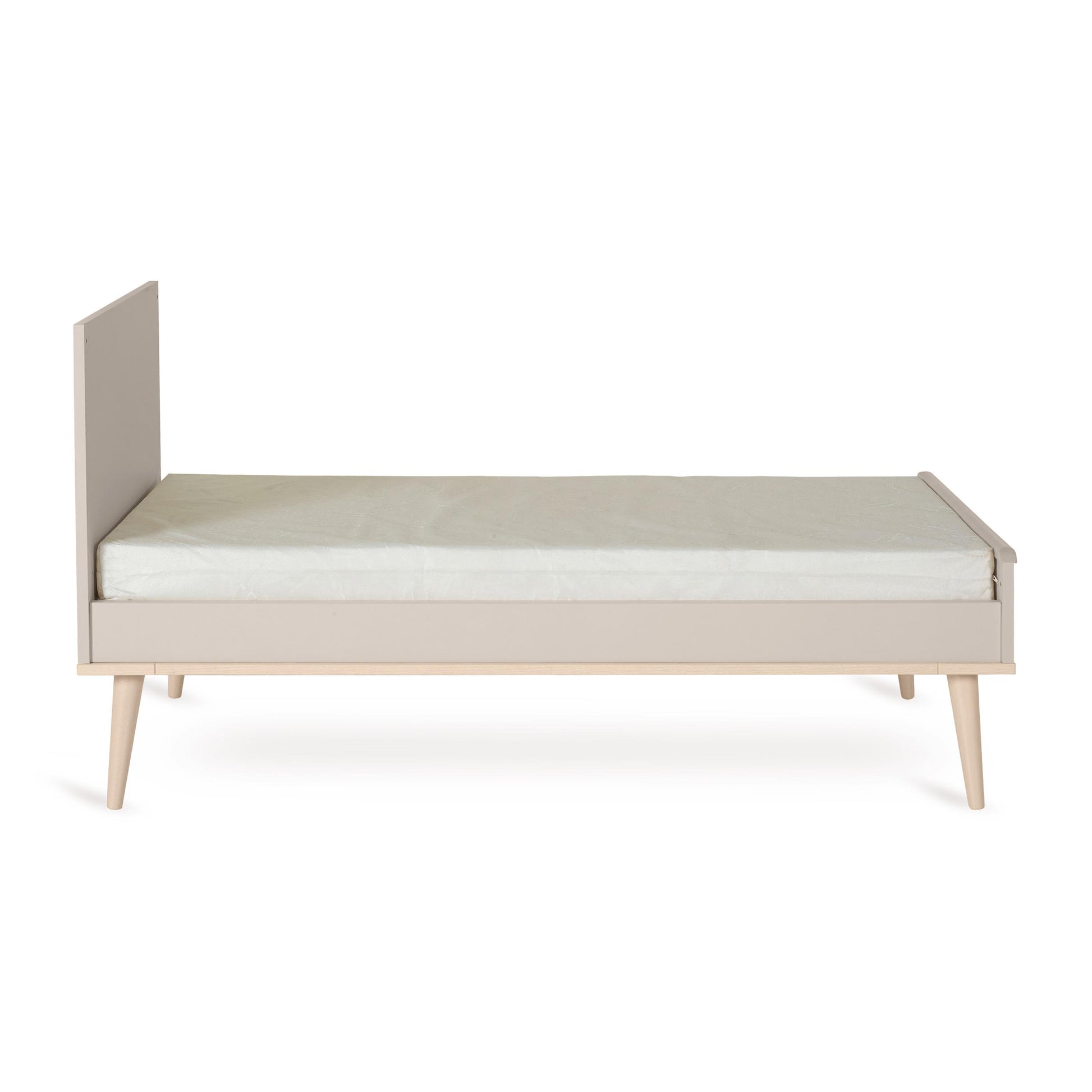 Quax Flow Cot Bed converted to an open toddler bed in Clay with low side panel and wooden legs