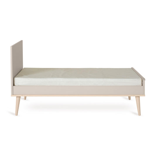 Quax Flow Cot Bed converted to an open toddler bed in Clay with low side panel and wooden legs