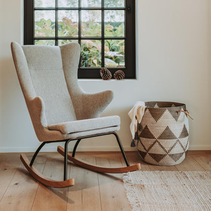 Rocking chair and woven basket in a room with a window